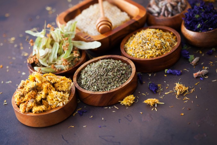 Assorted dried herbs and natural ingredients in wooden bowls, representing herbal medicine, holistic healing, and natural remedies.