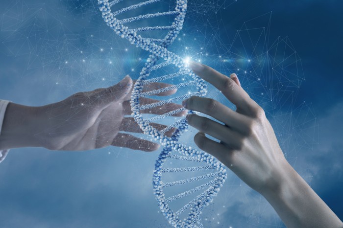 Hands interacting with a glowing DNA double helix on a futuristic blue background