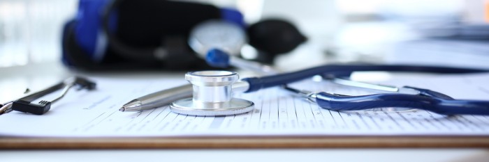 Stethoscope resting on medical records — representing conventional healthcare and the biochemical model of medicine